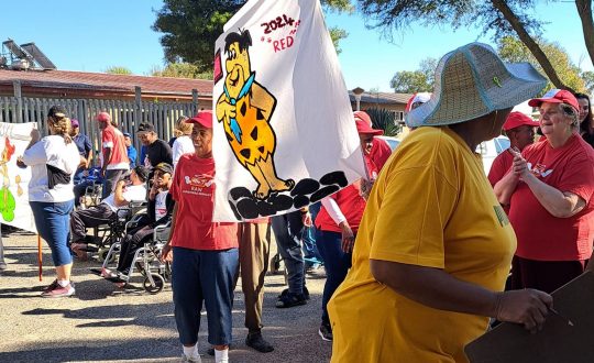 Vita Noveans standing in their respective teams with their homemade flags