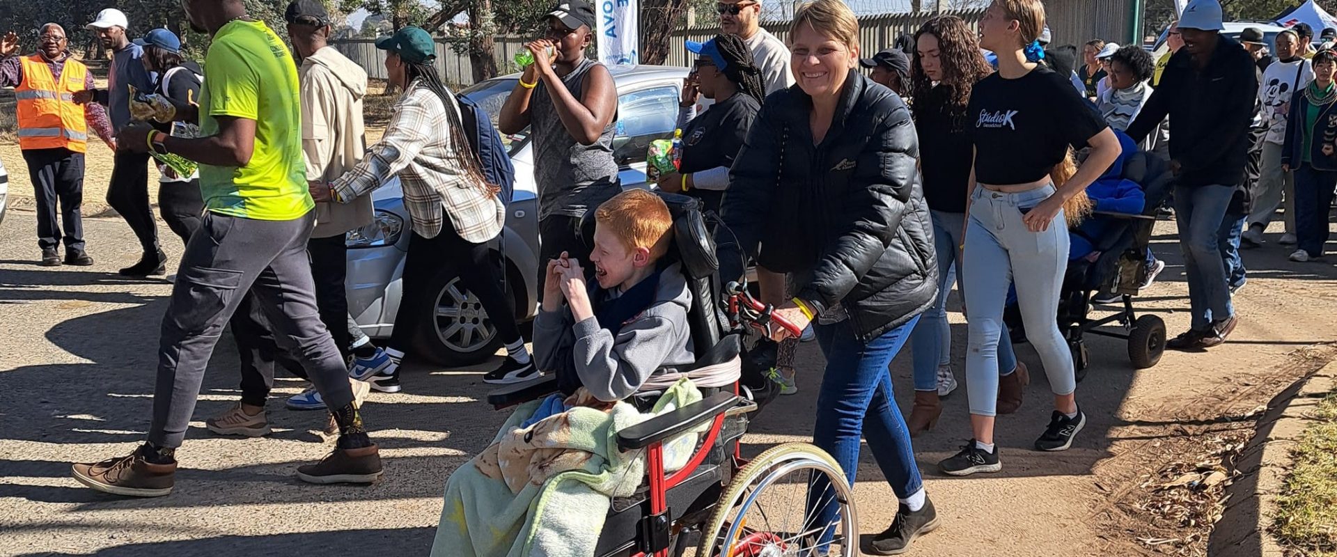 A participant pushing one of our residents in our annual walk
