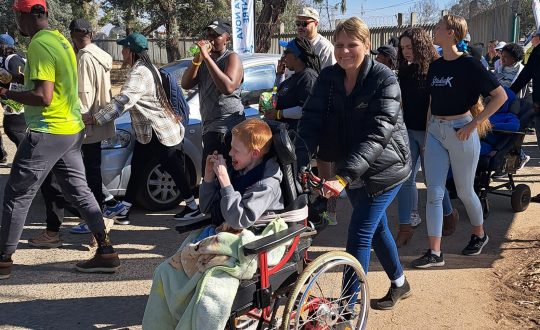 A participant pushing one of our residents in our annual walk