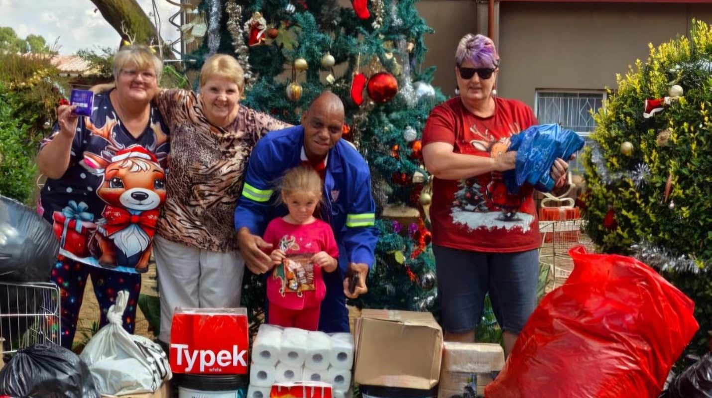 Workers of Vita Nova standing in front of Christmas tree with donations from Pinegrove Primary